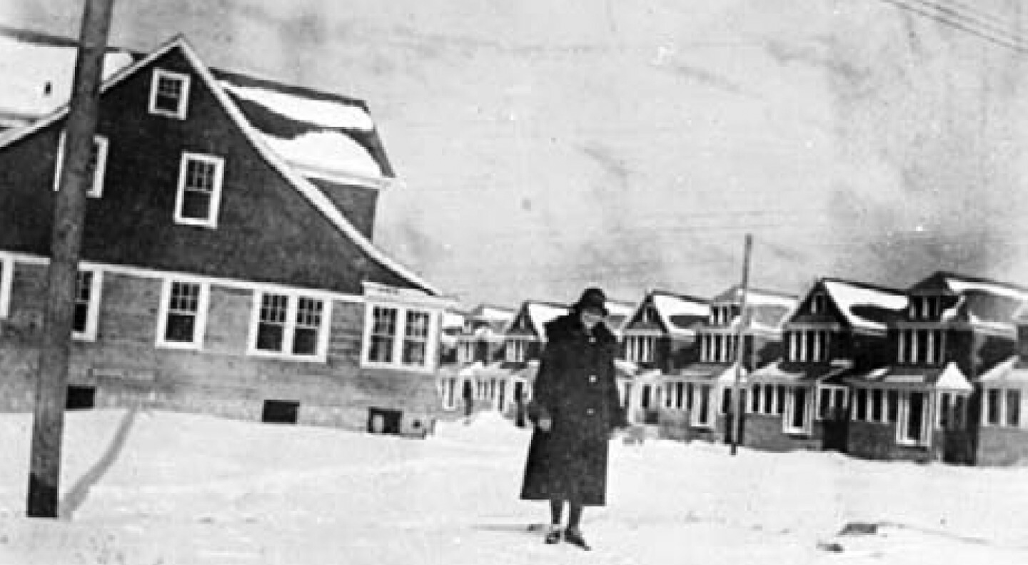 An unidentified woman stands before unfinished homes in the Liberty Park section of Glendale following a February 1926 snowstorm.